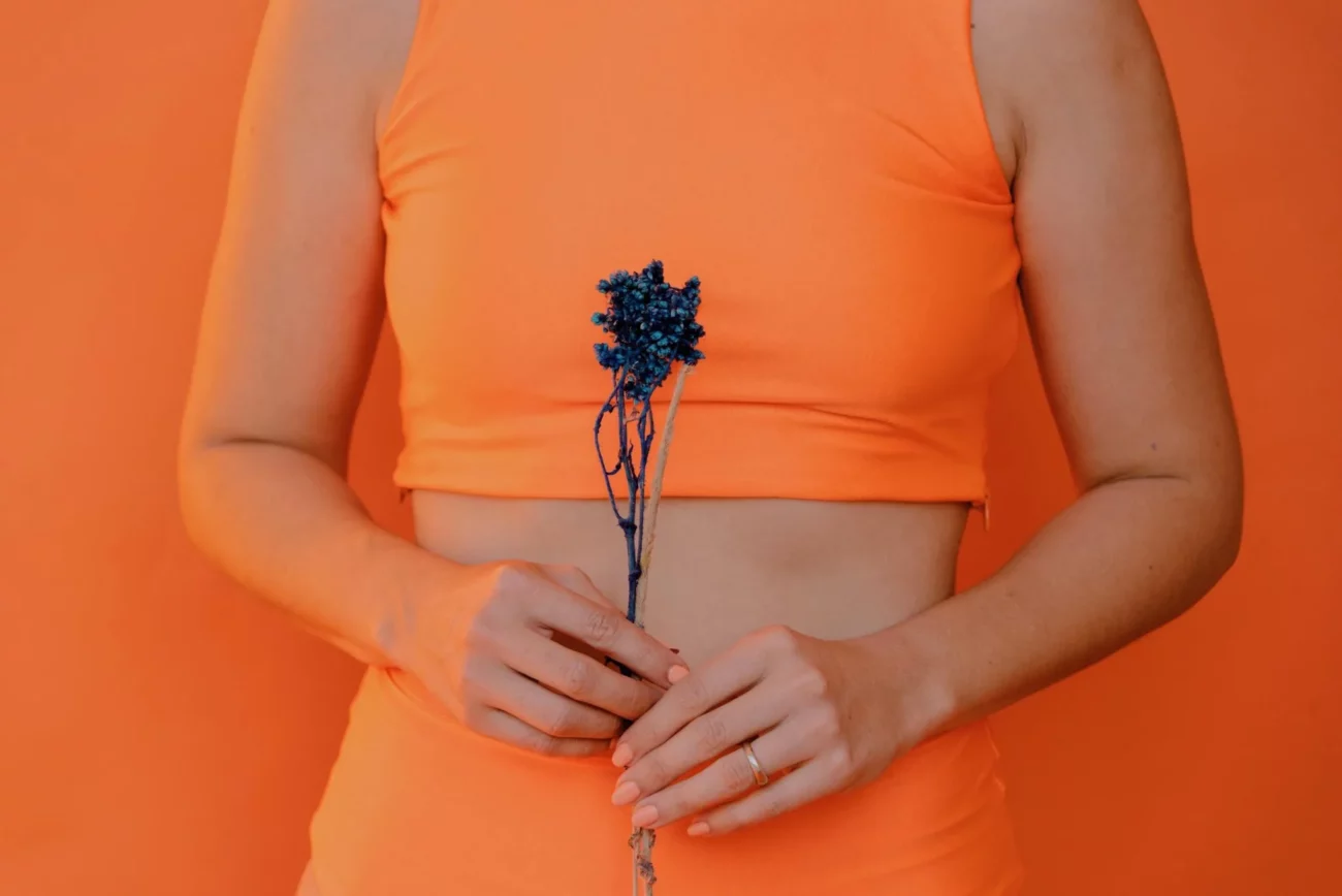 person dressed in orange holding a flower