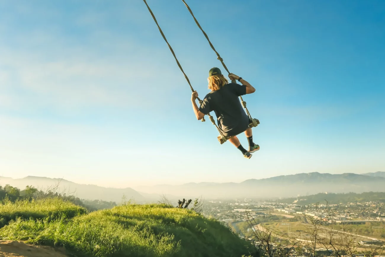 a man with a gluten free lifestyle swinging above a valley